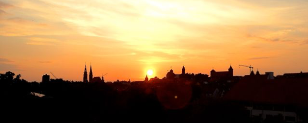 Silhouette der Nürnberger Altstadt mit Kirchtürmen und Burg im Gegenlicht der untergehenden Sonne
